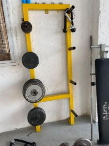 a yellow frame with weights on a wall at Ground floor apartment with gym & yard in Paggaio in Próti +10 photos