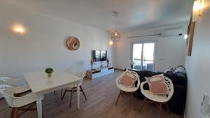ein Wohnzimmer mit einem Sofa, einem Tisch und Stühlen in der Unterkunft Albufeira Oura Beach Apartment in Albufeira