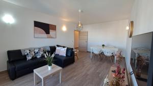 ein Wohnzimmer mit einem schwarzen Sofa und einem Tisch in der Unterkunft Albufeira Oura Beach Apartment in Albufeira