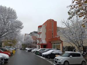 una calle nevada con coches aparcados frente a un edificio en Hotel Bliss, en Bucarest