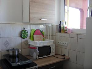 Il comprend une cuisine équipée d'une cuisinière et d'un four micro-ondes. dans l'établissement Apartament Obrońców Wybrzeża, à Gdańsk