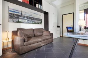 a living room with a couch and a glass table at Loft Santa Giulia in Turin