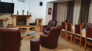 sala de estar con sillas de cuero y chimenea en ALISIO, en Sinaia