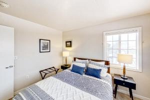 ein Schlafzimmer mit einem Bett mit blauen Kissen und einem Fenster in der Unterkunft Sunray Meadows 1109 in Steamboat Springs