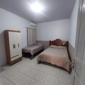 a bedroom with two beds and a cabinet in it at Flat JM in Parauapebas