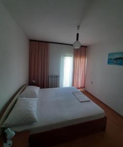 a large bed in a bedroom with a window at Apartman Juresic in Rab