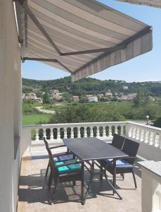 a patio with a table and chairs on a balcony at Apartman Juresic in Rab