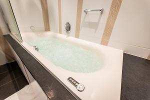 a jacuzzi tub in a bathroom at Kasteel De Vanenburg in Putten