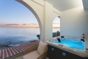Cette chambre dispose d'une baignoire et offre une vue sur l'océan. dans l'établissement Marina Apartments, à Kardamyli