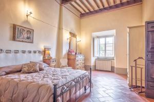 ein Schlafzimmer mit einem Bett, einer Kommode und einem Fenster in der Unterkunft Casa Coppi - Together in Tuscany in Cortona