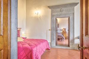 ein Schlafzimmer mit einem rosa Bett und einem Spiegel in der Unterkunft Casa Coppi - Together in Tuscany in Cortona
