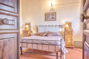 ein Schlafzimmer mit einem Bett mit zwei Nachttischen und zwei Lampen in der Unterkunft Casa Coppi - Together in Tuscany in Cortona