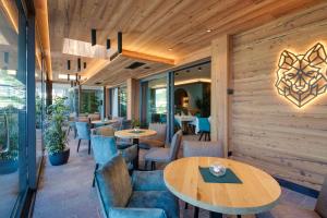 a restaurant with wooden walls and tables and chairs at Hotel Fontanella in Molveno