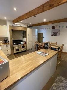 una cucina con piano di lavoro e una sala da pranzo di Wuthering Cottage - Central, Stylish, Cosy, Comfy a Haworth