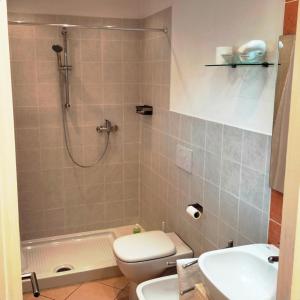 a bathroom with a shower and a toilet and a sink at Casa Laura in Magliano Alfieri