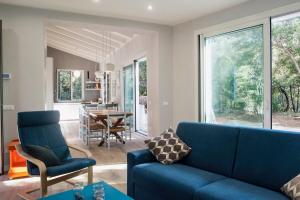a living room with a blue couch and a table at Villa Duna Blu in Baratti