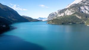 a lake in the middle of a mountain range at Hotel Fontanella in Molveno