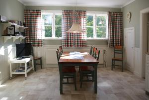 a dining room with a table and chairs and windows at Olsbacka Gård in Falun