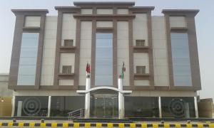 a building with two flags in front of it at نخلة الصحراء للشقق المخدومة in Al Nairyah