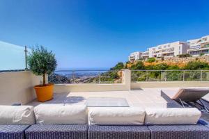 un divano su un balcone con vista sull'oceano di 1090 amazing panorama sea view penthouse large terrace heated pool gym a Marbella