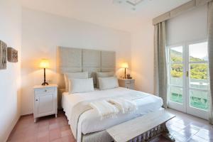 a bedroom with a large white bed and a window at Santavenere Hotel in Maratea