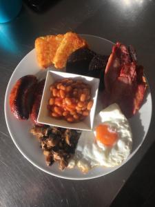 a plate of breakfast food with eggs beans and bacon at The Millbrook B&B in Torquay +36 photos