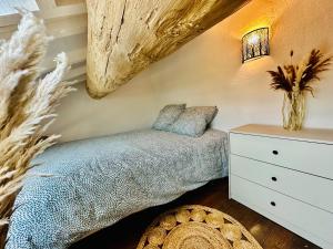 a bedroom with a bed and a dresser at La Bohème : Gardon et Pont Du Gard in Remoulins