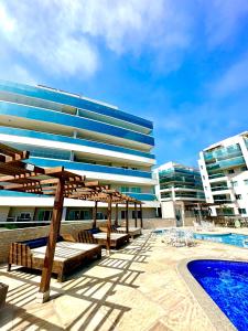 um resort com piscina e um edifício em Apartamento até 8 Pessoas Praia Grande - Le Bon Vivant em Arraial do Cabo