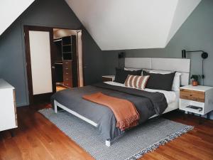 a bedroom with a large bed with an orange blanket at Modern Retreat near Traverse City in Cedar