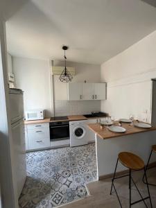 uma cozinha com armários brancos e um forno com placa de fogão em Duplex avec Clim centre de nimes em Nîmes