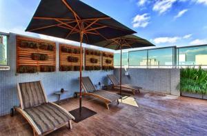 a patio with two chairs and an umbrella at Apto 303- Flat Paraíso in Sao Paulo