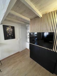 a living room with a large black entertainment center at Charmant Duplex centre de nimes in Nîmes