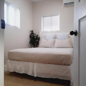 biała sypialnia z dużym łóżkiem z białą pościelą w obiekcie Villa By The Bay w mieście Nassau