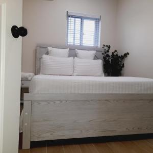 um quarto com uma cama com lençóis brancos e uma janela em Villa By The Bay em Nassau