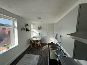 a kitchen with a sink and a table in it at Harbour Flats in Skegness