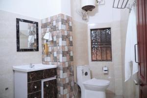 La salle de bains est pourvue de toilettes, d'un lavabo et d'un miroir. dans l'établissement ROYALTY GLOBAL HOMESTAY, à Shillong