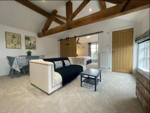 a living room with a white couch and a table at Evelith Manor Barns in Shifnal