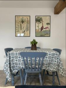 a dining room table with four chairs and two pictures of animals at Evelith Manor Barns in Shifnal