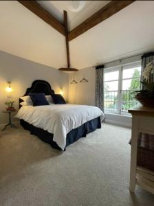 a bedroom with a large bed and a large window at Evelith Manor Barns in Shifnal