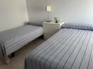 2 camas individuales en una habitación con mesita de noche en Apartamento con Vistas Panorámicas, en Sueca