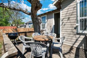 uma mesa e cadeiras num alpendre com uma árvore em Soledad - A Birdy Vacation Rental em San Antonio
