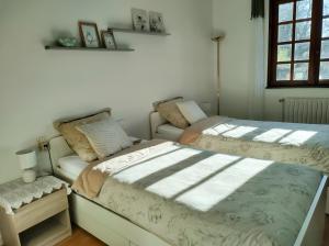 a bedroom with two beds and a couch at Gîte les deux sources au pied du Vercors in Saint-Laurent-en-Royans