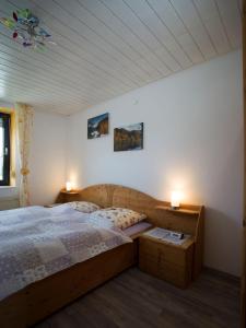 um quarto com uma cama de madeira e 2 candeeiros em Ferienwohnung Lisa em Freisen