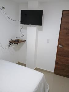 a room with a bed and a tv on a wall at HOTEL DI MAR in Cartagena de Indias