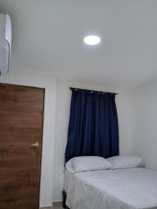 1 dormitorio con 2 camas y cortina azul en HOTEL DI MAR en Cartagena de Indias