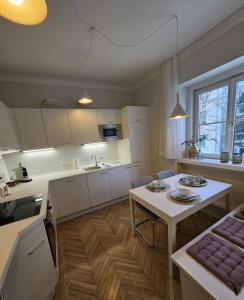 een keuken met witte kasten, een tafel en een wastafel bij Golden Flat by GrazRentals with parkview - brandnew & free parking in Graz