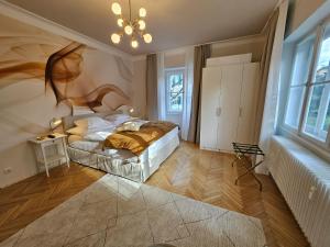 een slaapkamer met een bed en een kroonluchter bij Golden Flat by GrazRentals with parkview - brandnew & free parking in Graz