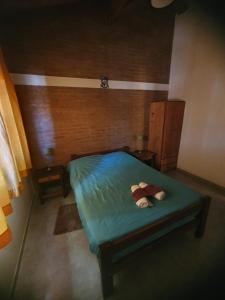 a small bedroom with a green bed with two towels at El Aguaribay de los Nonos in Mina Clavero
