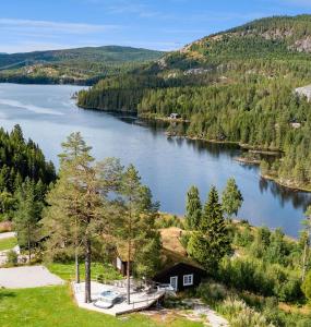 a view of a lake with a house and a dock at Libeli- panoramaview towards Gaustadtoppen- Jacuzzi in Lona