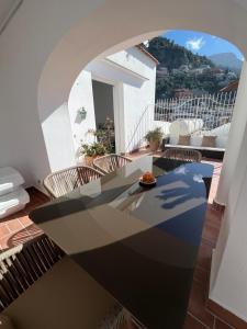 a room with a table and chairs on a balcony at Casa Positano in Positano